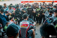 a group of people gathered around a motorcycle