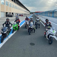 a group of people riding motorcycles on a track